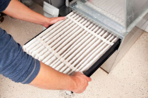 a technician installing a new air filter into an existing air conditioner