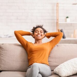 A woman relaxing on the couch after returning home to an air conditioned home